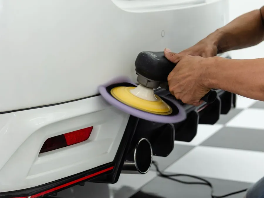 Person Polishing the Back of the White Car
