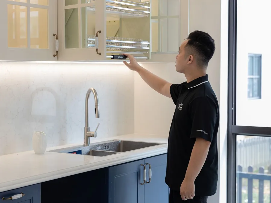 Man Adjusting Modern Kitchen Cabinet Shelf Interior