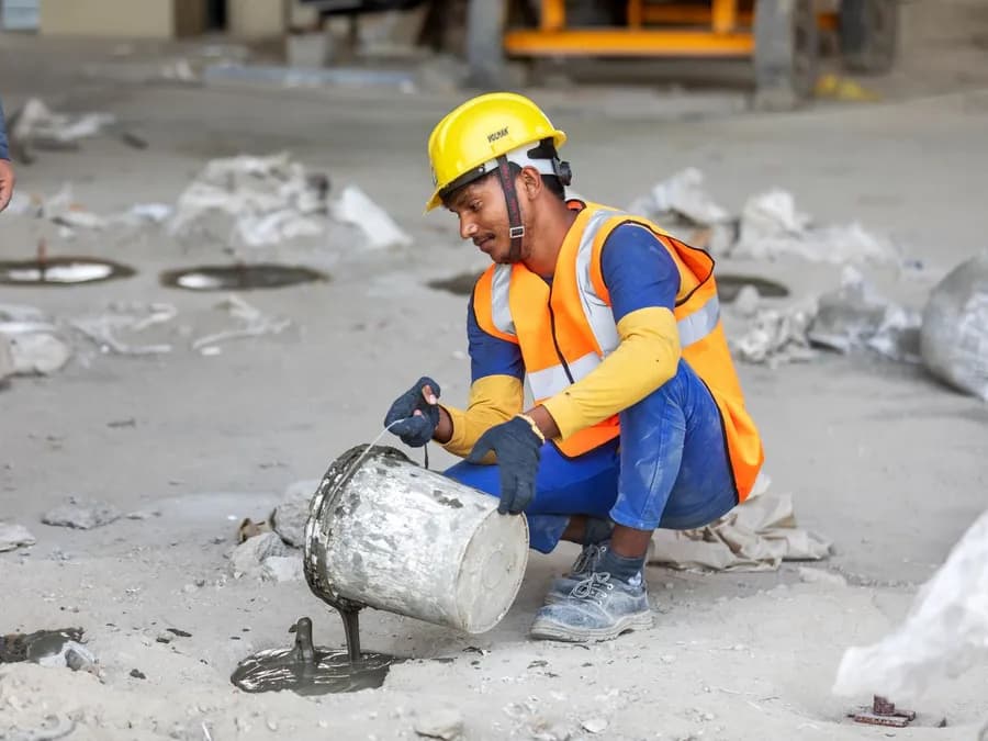 Construction Worker Pouring Concrete on Site