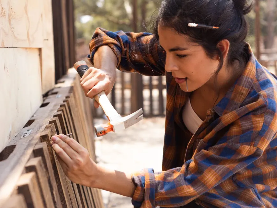 Woman Fixing Wooden Fence