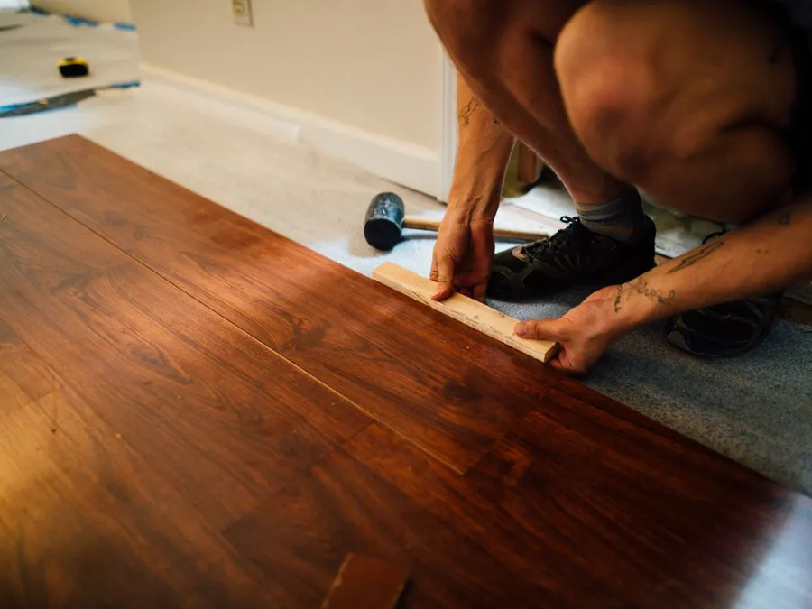 Crop man installing laminate flooring