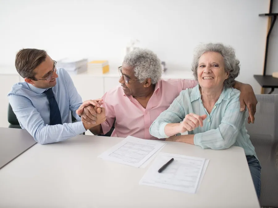 Insurance Agent Sitting Next to Smiling Clients