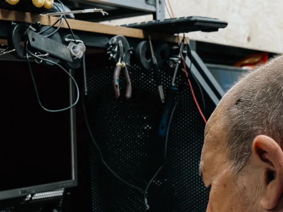 Man repairing electronic device at workshop desk