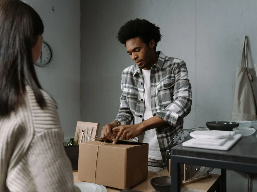 Photo of a Man Packing Up a Box for a Customer