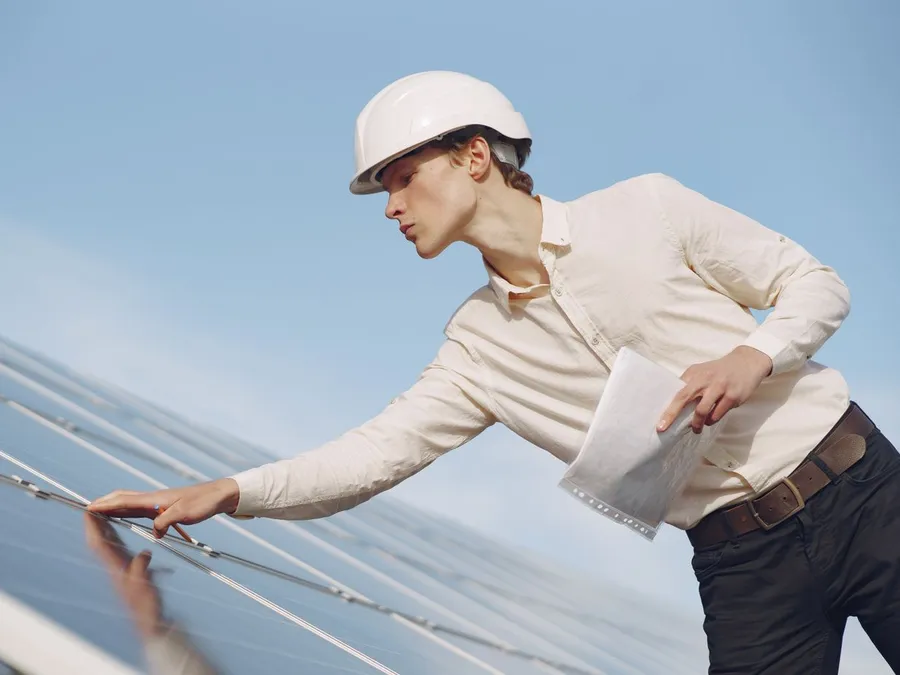 Solar Technician Inspecting Solar Panel