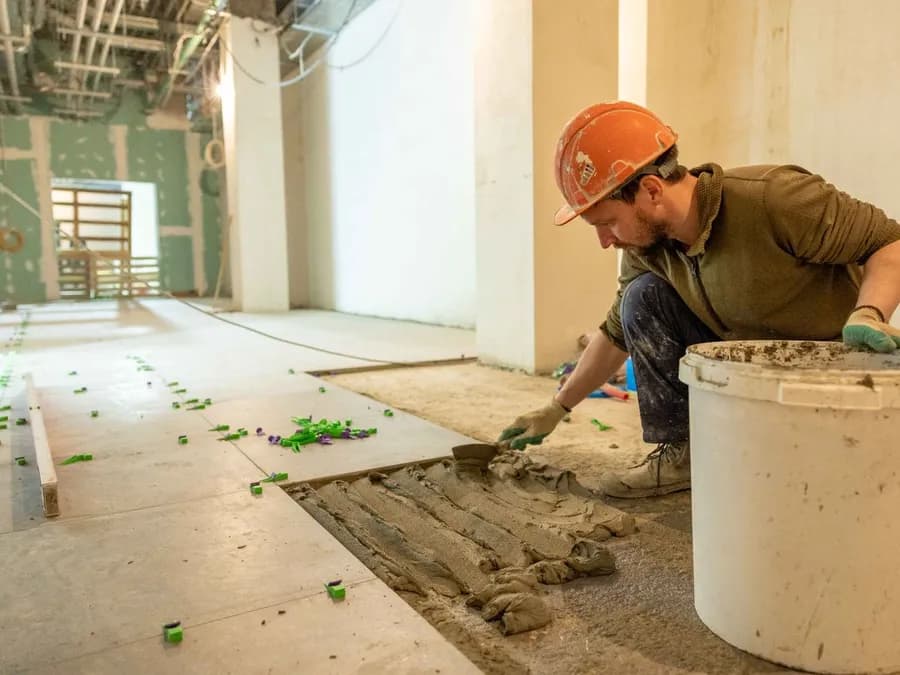 Construction Worker Laying Tile in Renovation Project